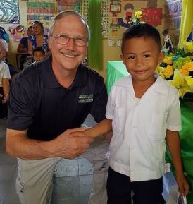 Bill Rivers congratulates a graduating kindergartener in Honduras